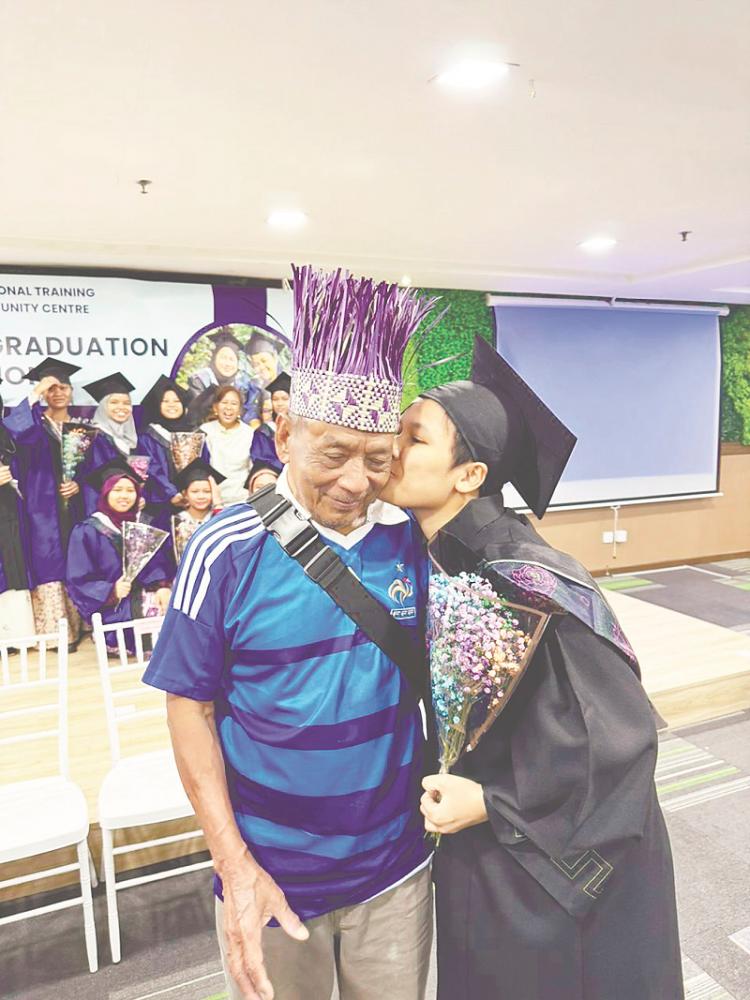 $!Orang Asli graduate Lauyeg Along, from Gua Musang, graduated from the hairdressing course. Her father attended the graduation.