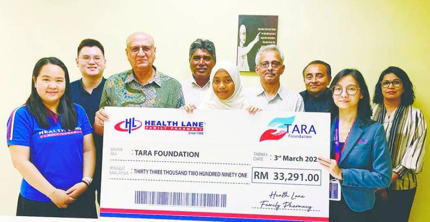 Pardip (third left) receives a mock cheque for RM33,291 on behalf of Tara Foundation from Yan (second right) of Health Lane Family Pharmacy.